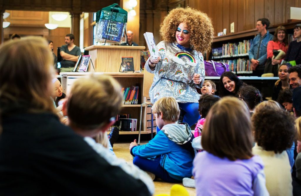 Lil Miss Hot Mess reads to a group of children at a Drag Queen Story Hour event